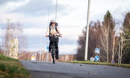 Pyöräilijä polkee kadulla.