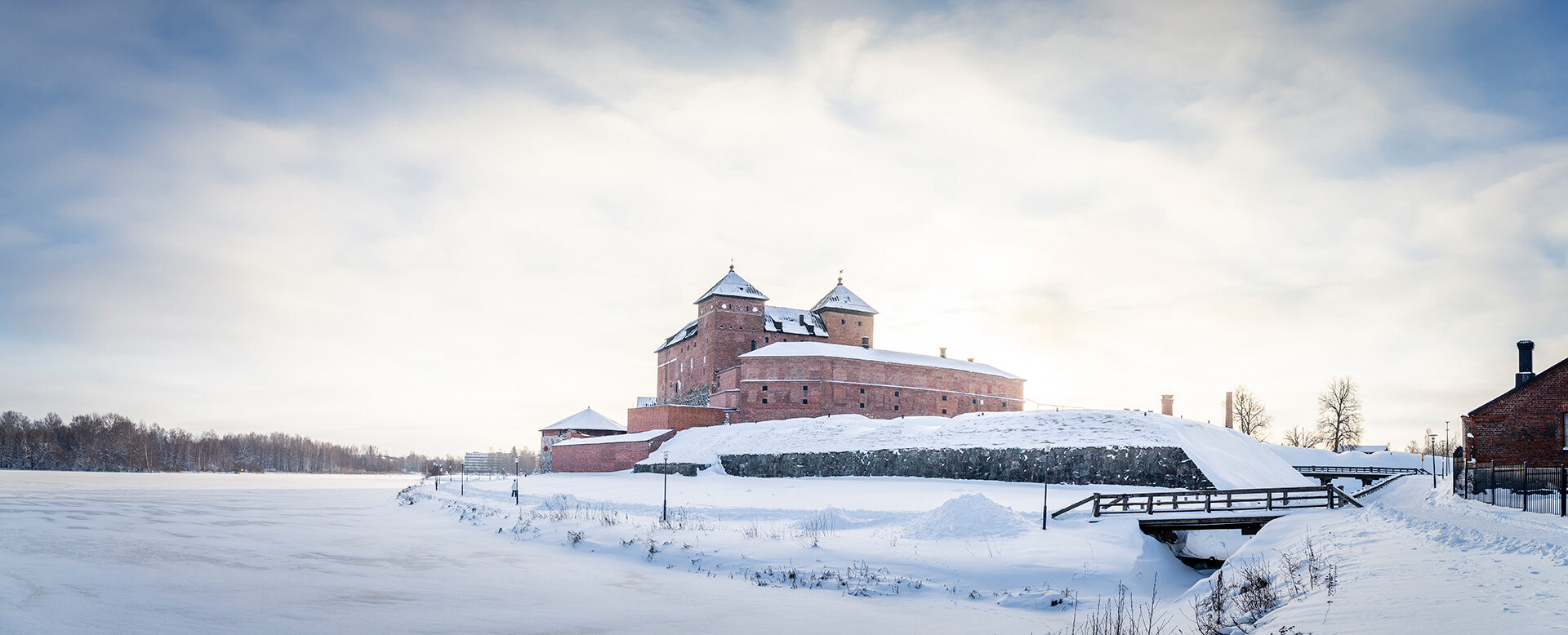 Punatiilinen Hämeen linna talvisessa maisemassa.