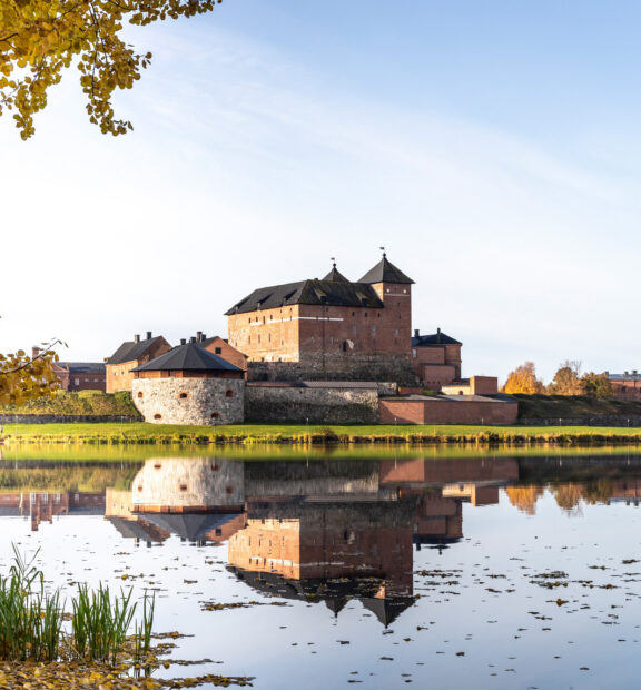 Järven rannalla sijaitseva punatiilinen Hämeen linna