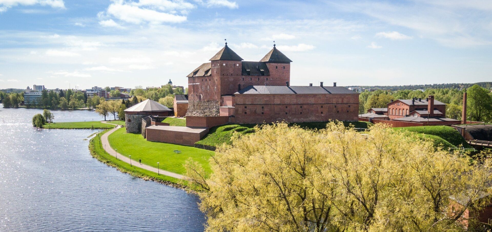 Järven rannalla oleva punatiilinen Hämeen linna.