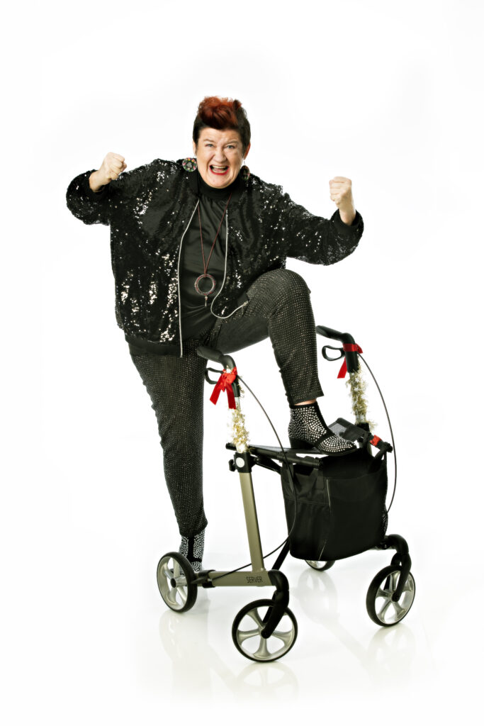 Nainen pitää toista jalkaansa rollaattorin päällä.