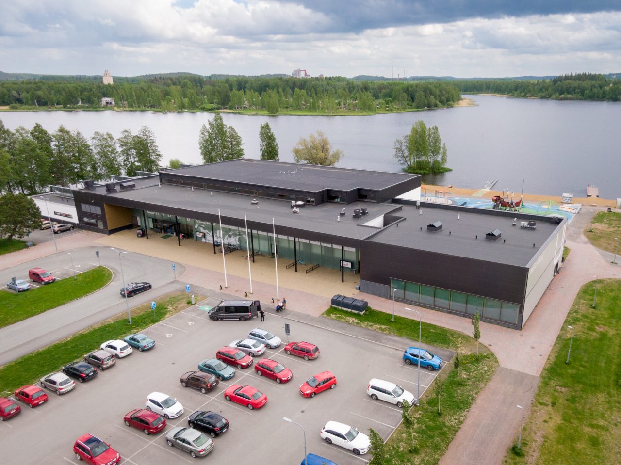 Ilmakuva Hämeenlinnan uimahallin rakennuksesta, uimahallin edessä parkkipaikka.