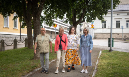 Ryhmä ihmisiä kävelemässä puiston läpi kulkevalla kevyen liikenteen väylällä.