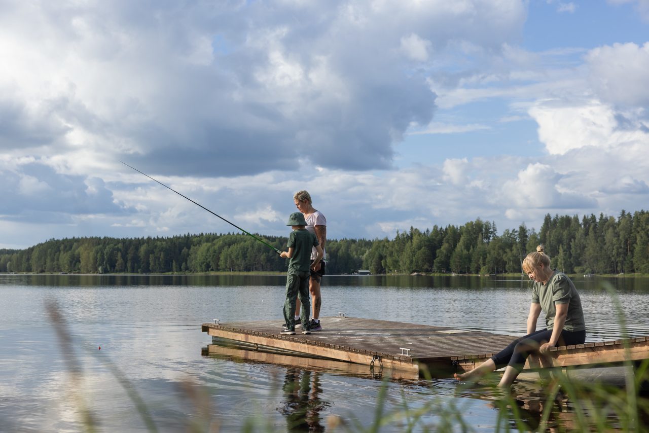 Nainen ja lapsi ovat mato-ongella laiturilla.
