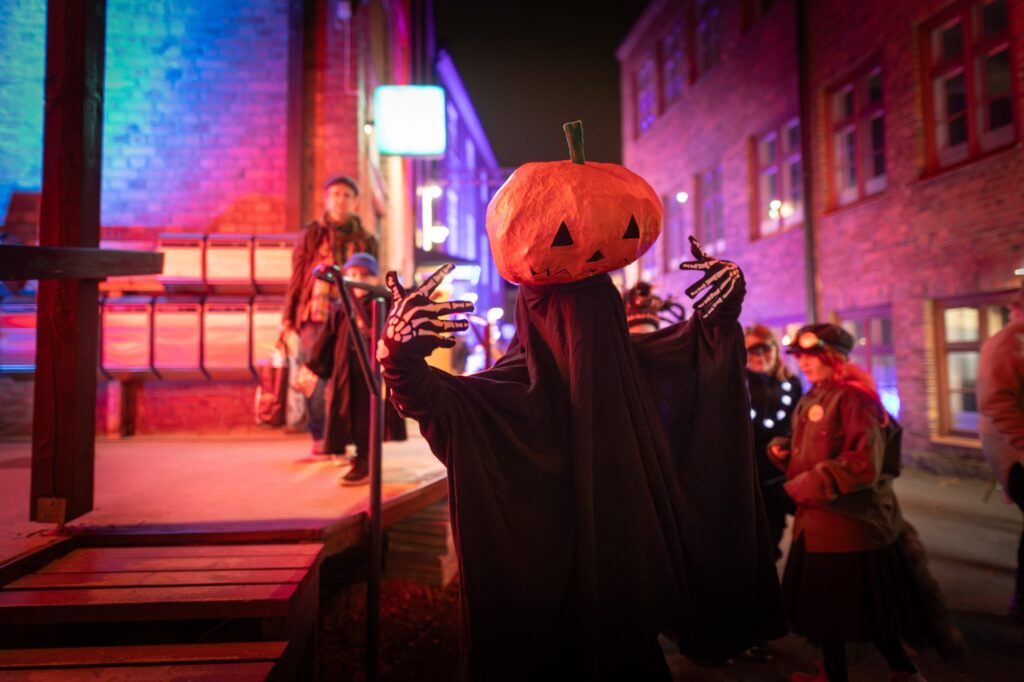 Kurpitsahahmo yleisön seassa Verkatehtaalla