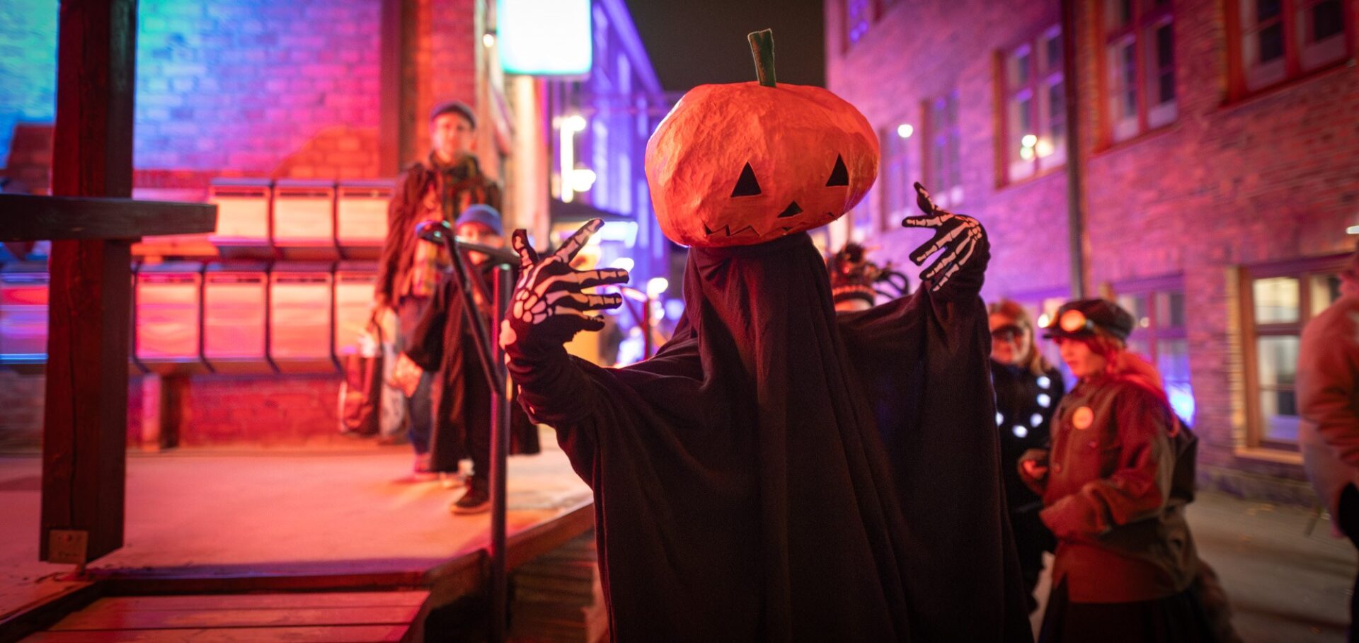 Kurpitsahahmo yleisön seassa Verkatehtaalla.