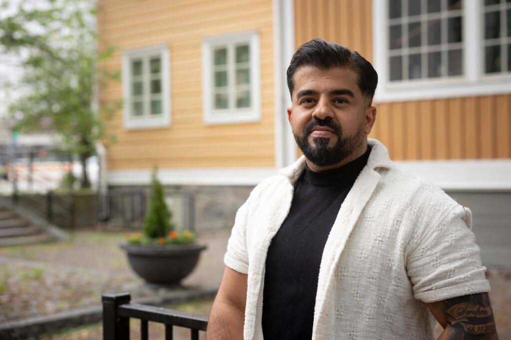 Henkilö katsoo kameraan ja hymyilee.