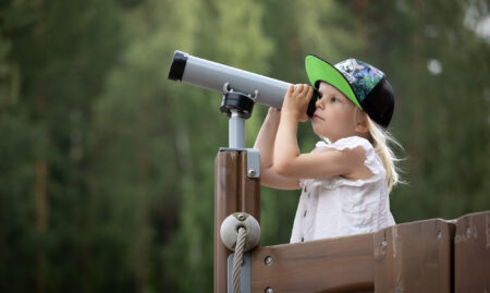 Lapsi katsoo kaukoputkella.