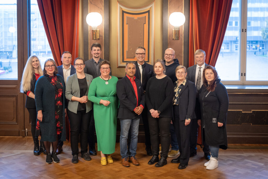 Hämeenlinnan kaupunginhallituksen edustajat ryhmäkuvassa Raatihuoneen juhlasalissa.