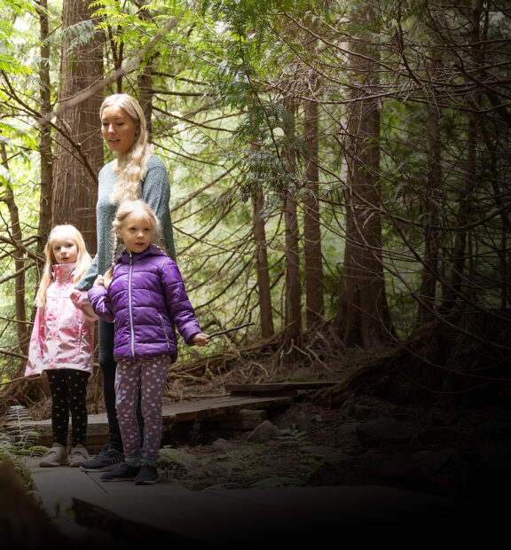 Lapsiperhe seikkailee Aulangon tuijametsässä.
