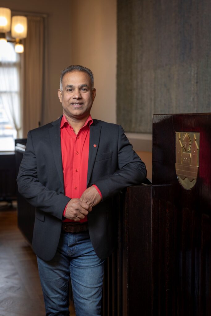 Hämeenlinnan kaupunginhallituksen puheenjohtaja Ranjith Kumar Prabhakaran seisoo valtuustosalin puhujakorokkeen edessä.