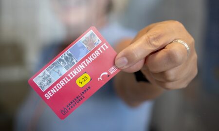Henkilö pitää kädessään senioriliikuntakorttia.