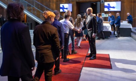 Kaupunginjohtaja kättelee oppilaita.