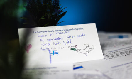 Pöydällä oleva kortti, johon hämeenlinnalainen lapsi on kirjoittanut rauhanviestin.