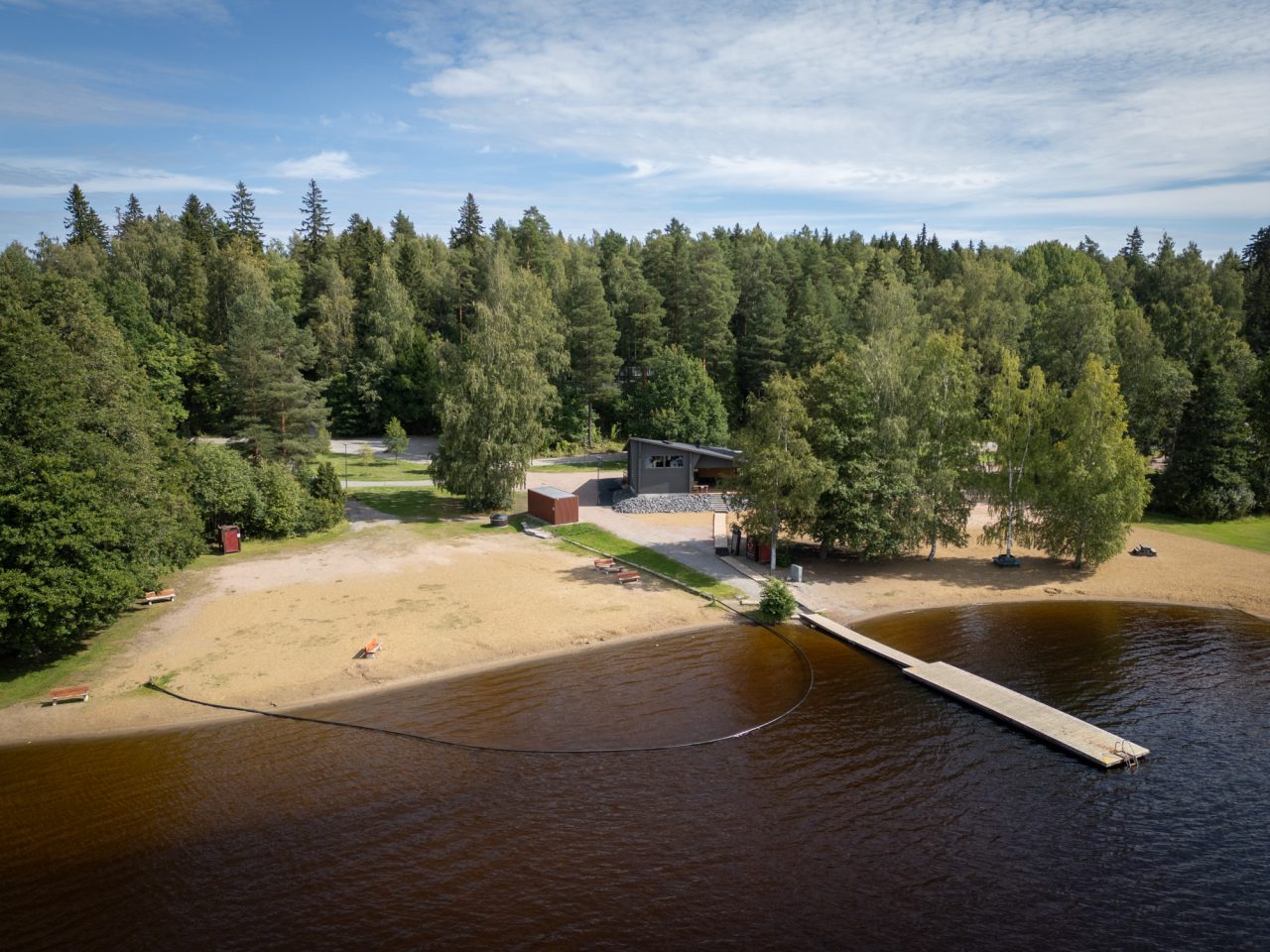Tervaniemen uimaranta, jossa pitkä laituri, saunarakennus ja iso hiekkaranta, sekä puomilla merkitty matalampi uintialue.