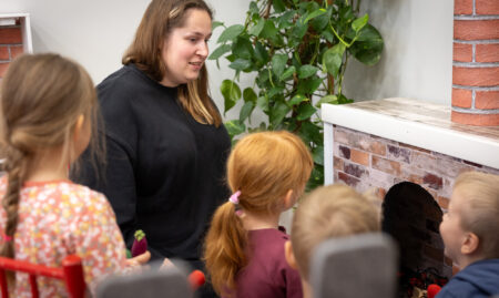 Aikuinen ja lapset leikkimässä Hirsmäen päiväkodissa.