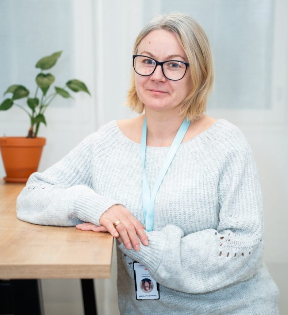 Anna Kolata katsoo kameraan ja hymyilee.