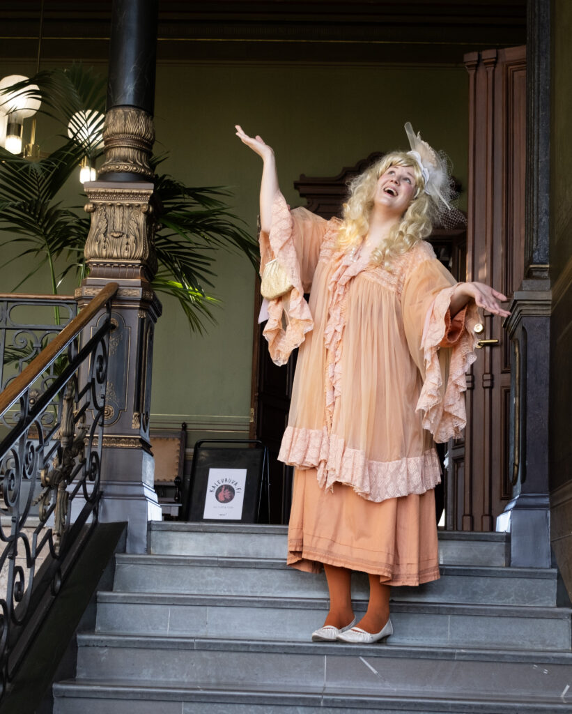 Röyhelömekkoinen hahmo rappusilla