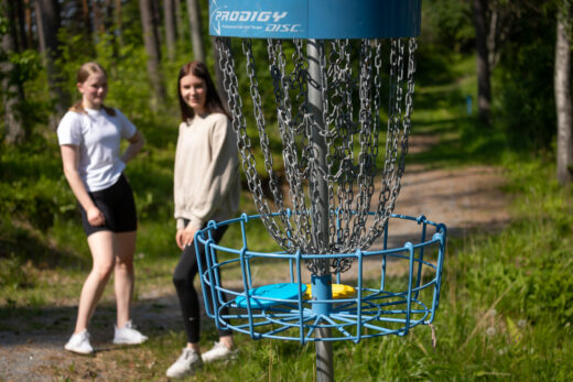 Two young people playing disc golf in Hauho.