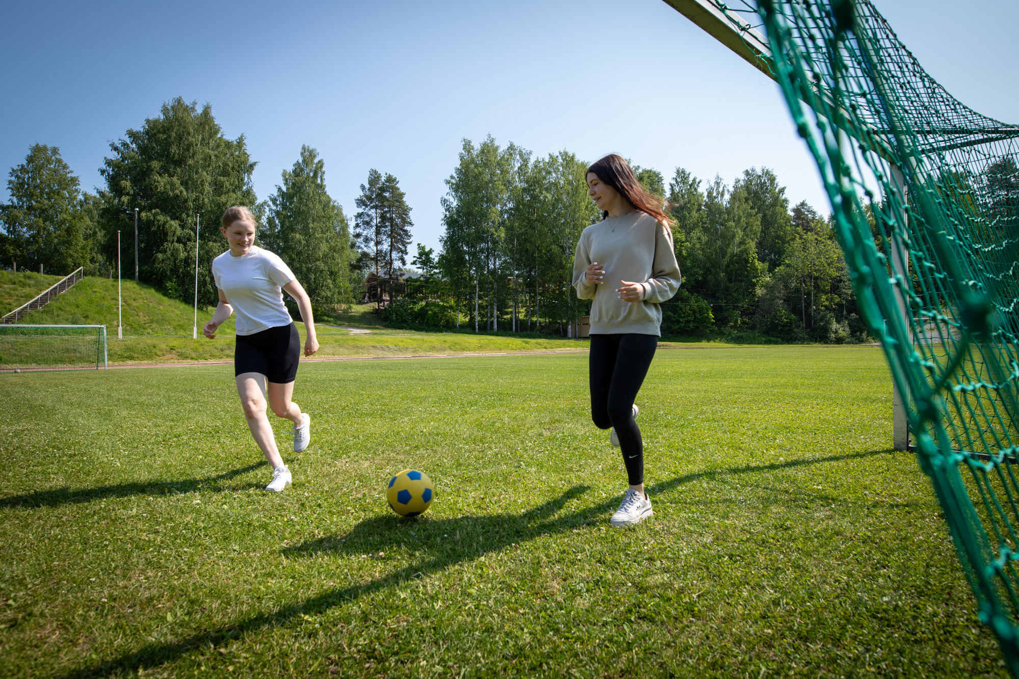 Kaksi nuorta pelaavat jalkapalloa.