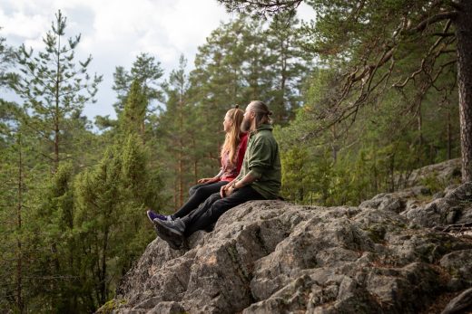 Kaksi ihmistä istuu Kärmeskalliolla.