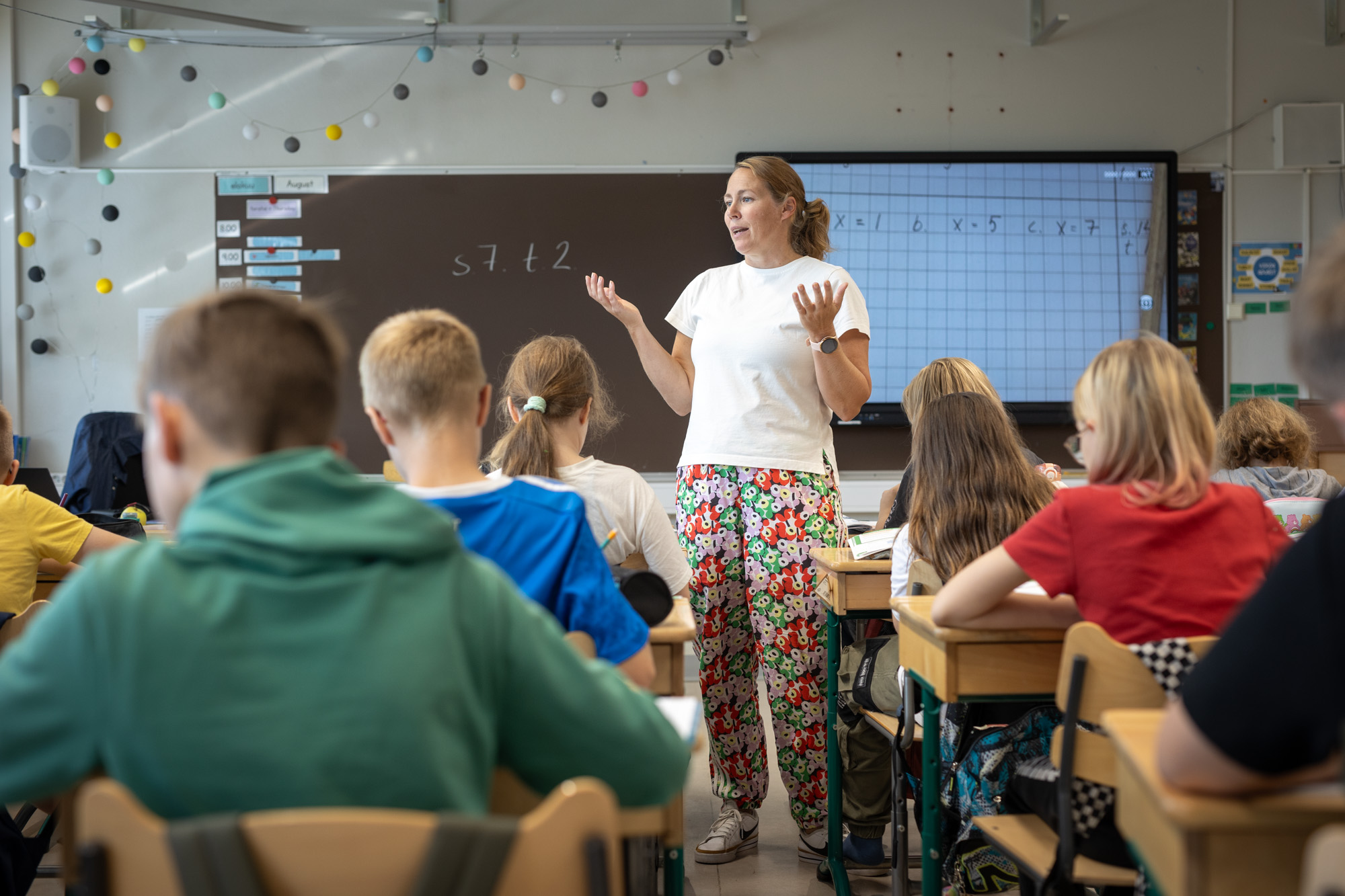 Opettaja opettaa matematiikkaa alakoululaisille.