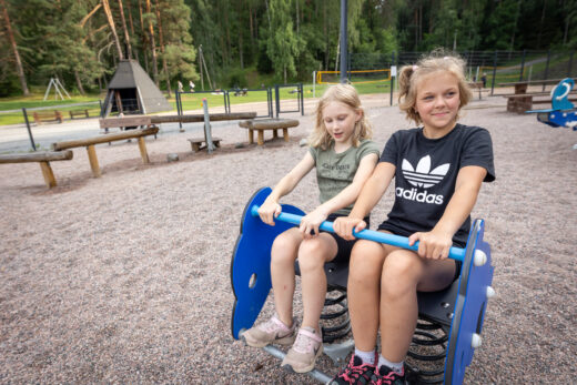 Kaksi lasta keinuvat Ahveniston leikkipaikalla.