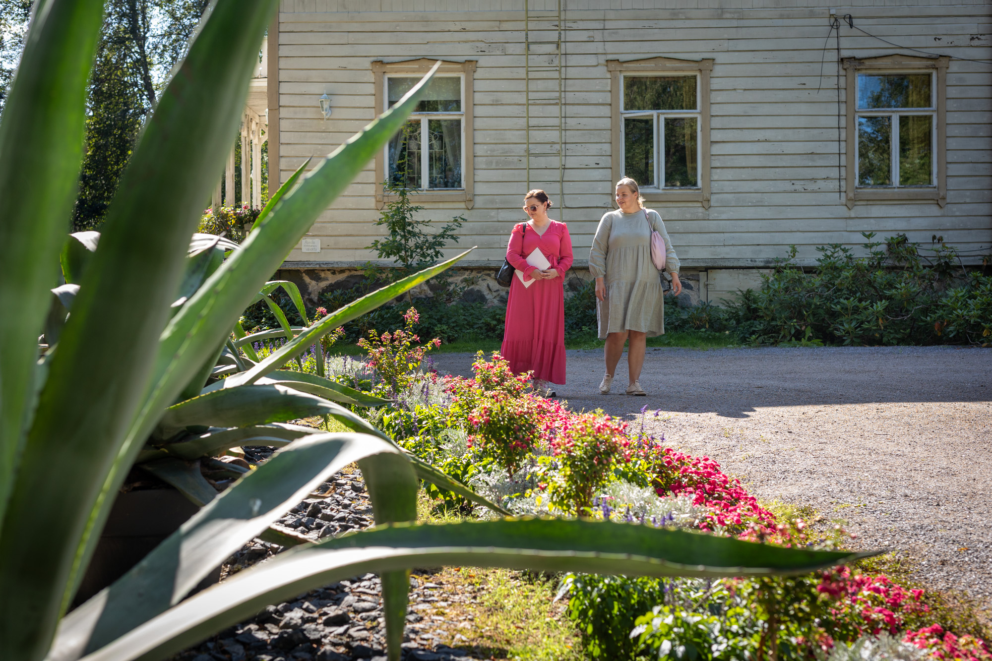 Two people walk in the courtyard of Porkkala Manor.