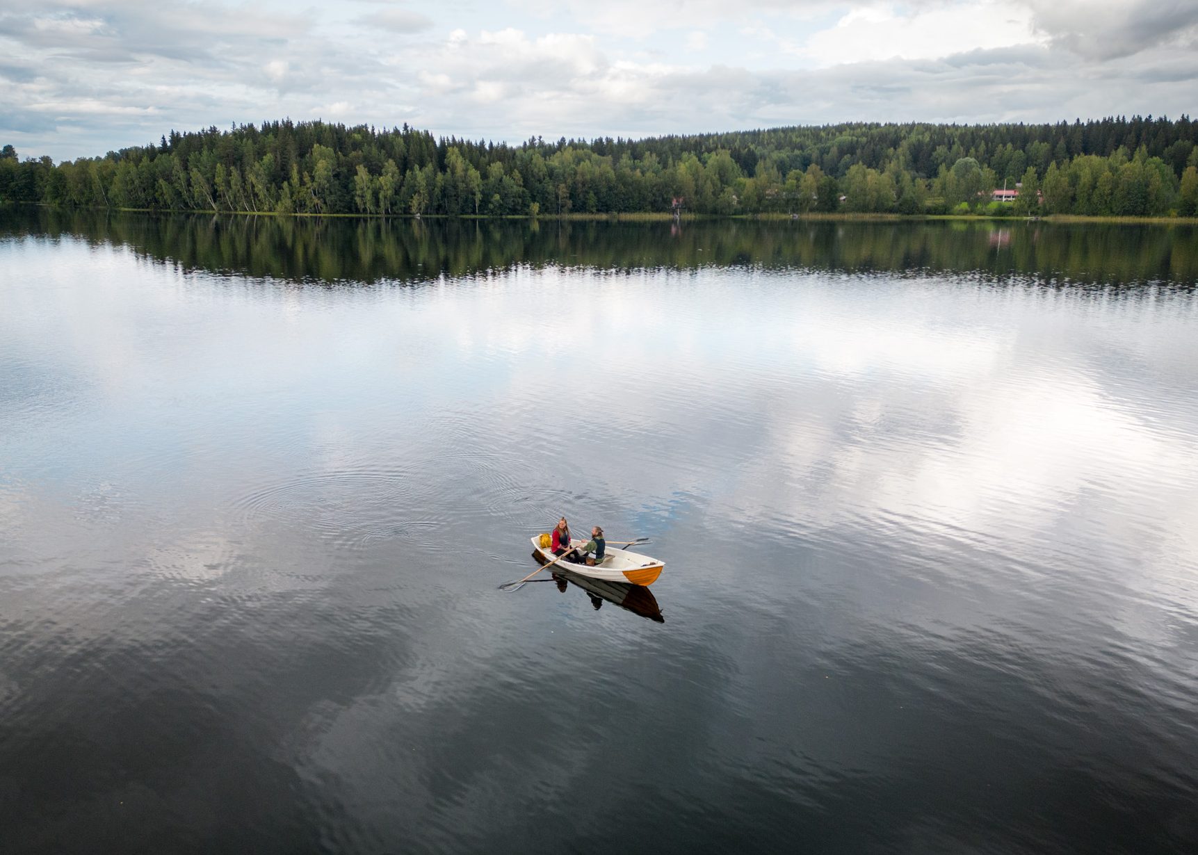 Aerial view of two people rowing a city boat.