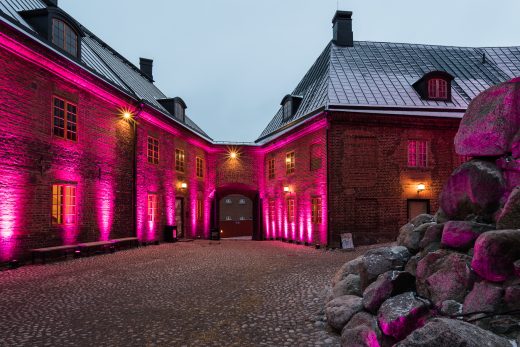 The castle's inner courtyard lit in bright red light. An arched door is visible at the back of the image.
