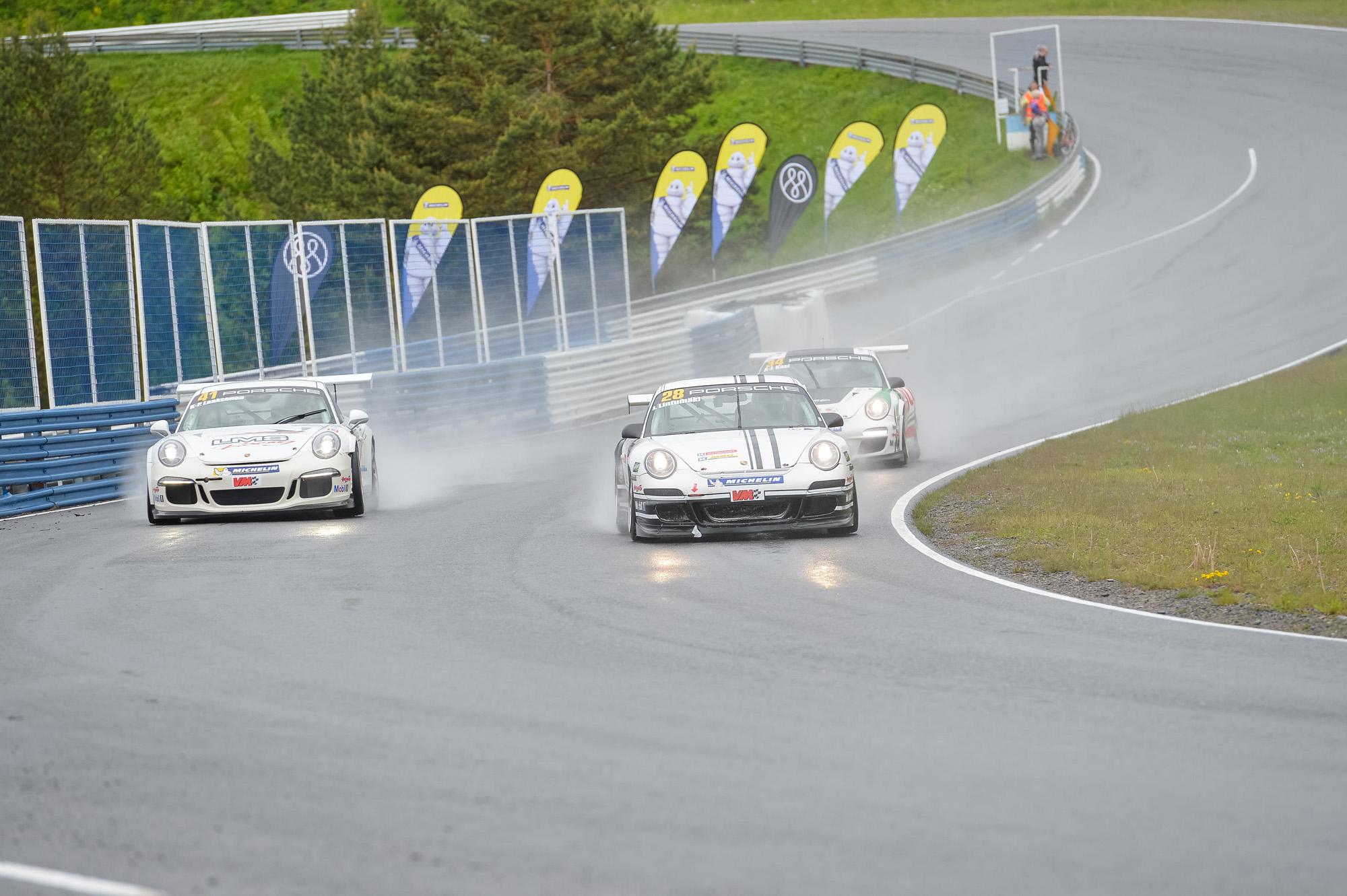 Three cars racing on the Ahveniston racetrack.