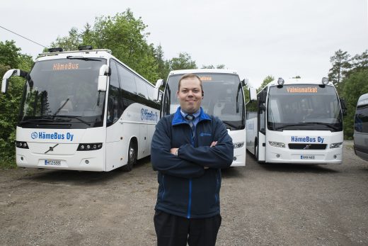 Yrittäjä Joonas Nieminen seisoo valkoisten bussin edessä.