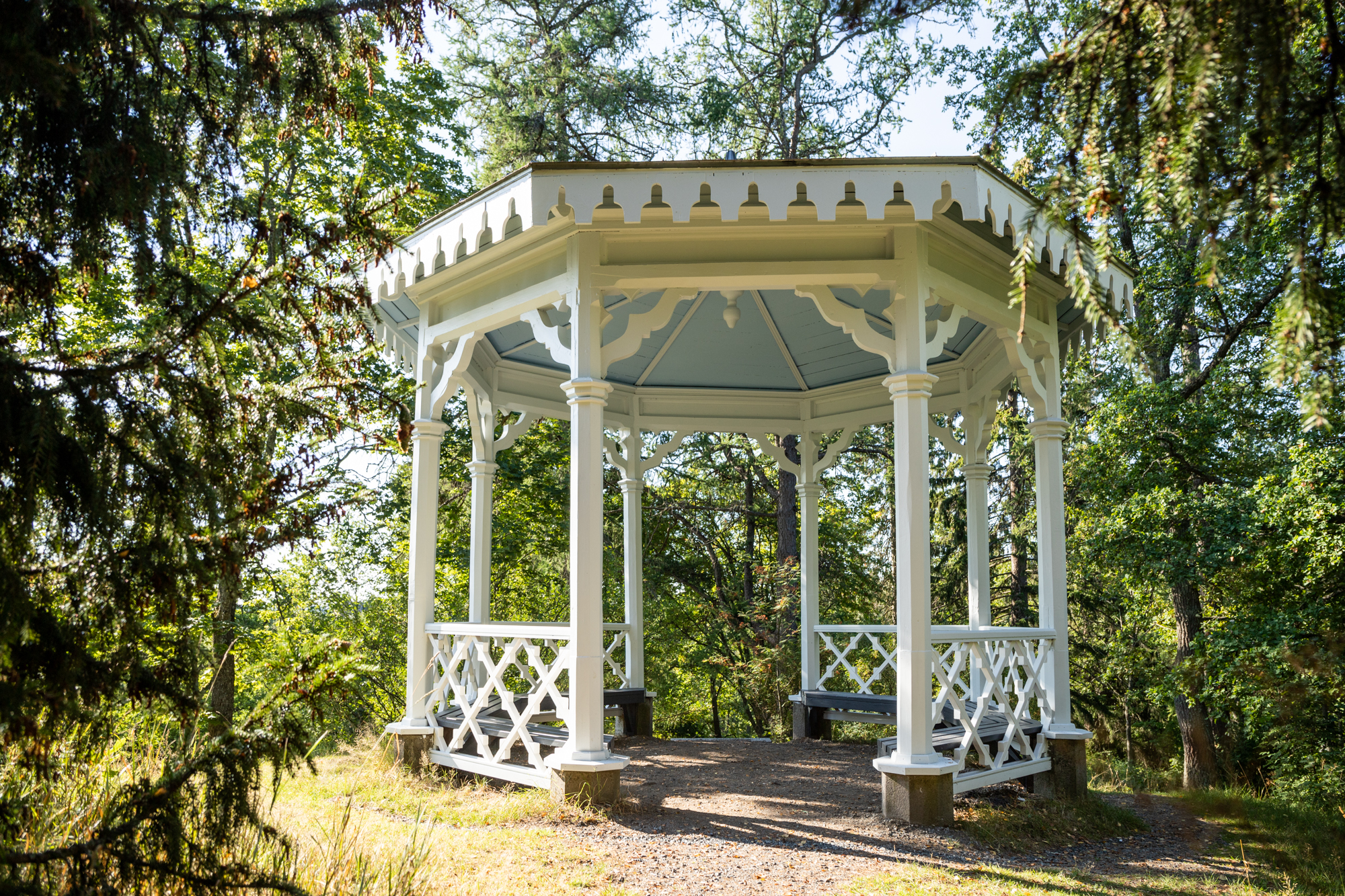 A wooden gazebo in the City Park, surrounded by trees.