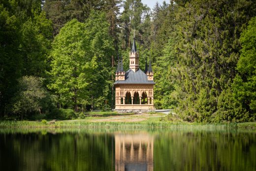 The Rose Valley Pavilion building surrounded by trees by the water.