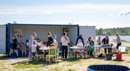 People sitting outside at tables participating in art activities.