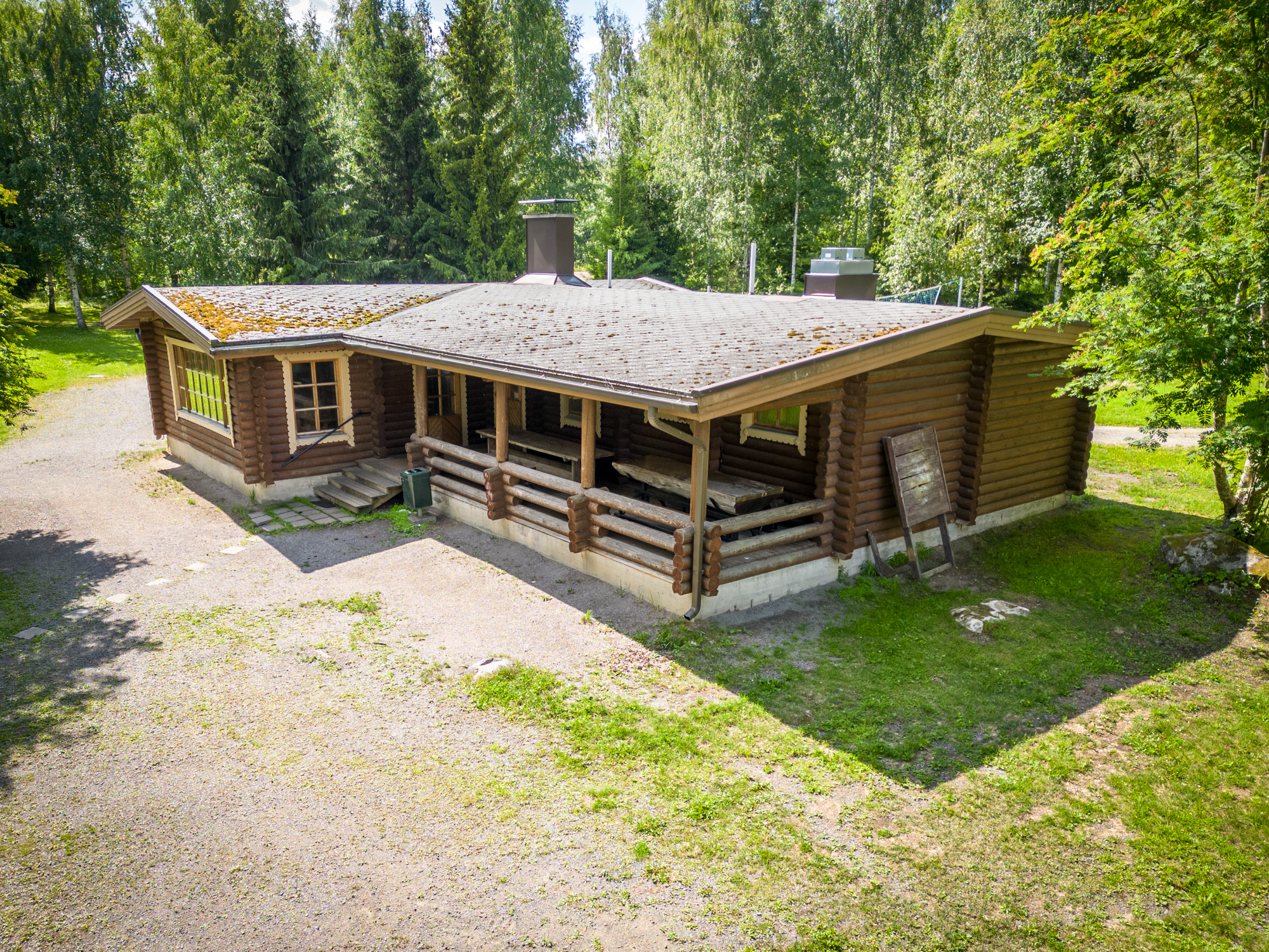 Lepaanrannan iso hirsimökki Nestori katettuine ulkoterasseineen.