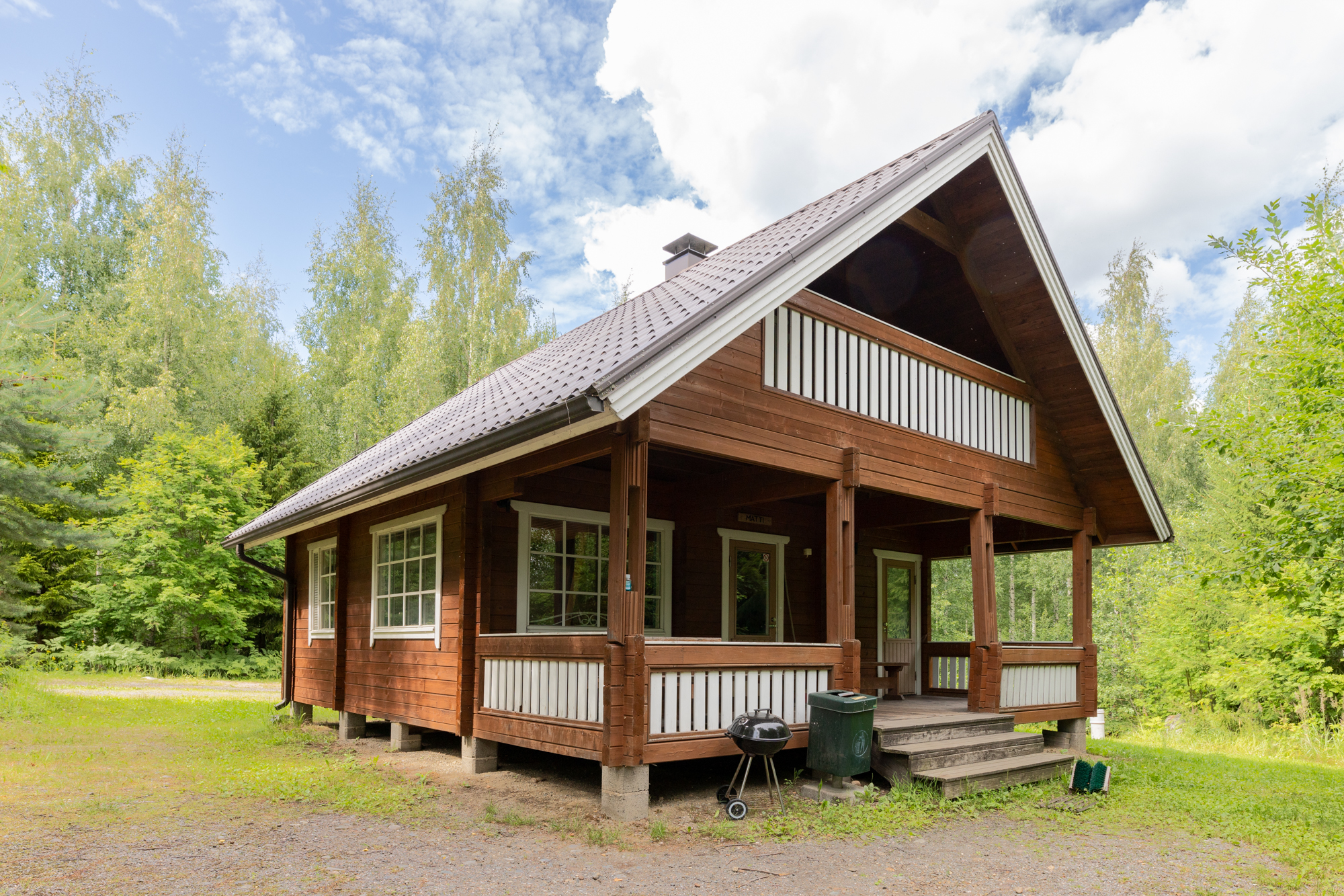 Lepaanrannan hirsinen majoitusmökki terasseineen.