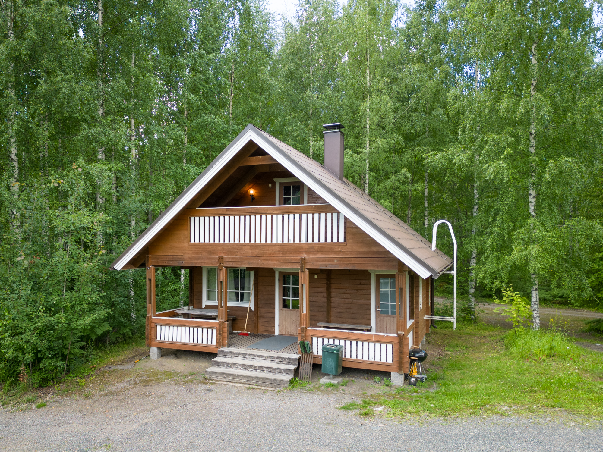 Lepaanrannan hirsinen majoitusmökki terasseineen.
