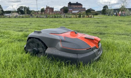 Linnanpuiston nurmikolla työskentelevä robottiruohonleikkuri.