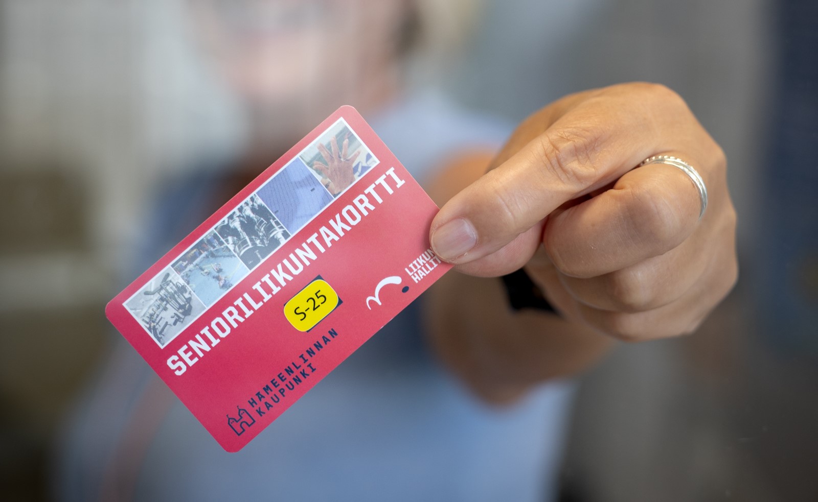 Henkilö pitää kädessään senioriliikuntakorttia.
