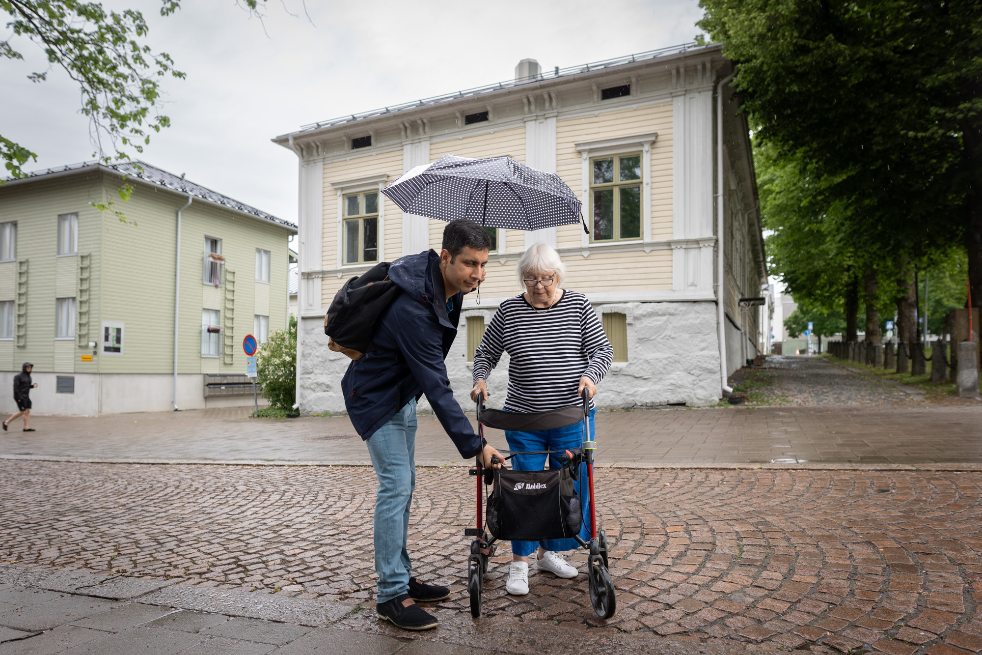 Vapaaehtoinen auttaa ikäihmistä ulkona.