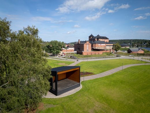 Hämeenlinnan Linnanpuistoon rakennettu uusi tapahtumalava, jonka taustalla näkyy punatiilinen Hämeen linna.