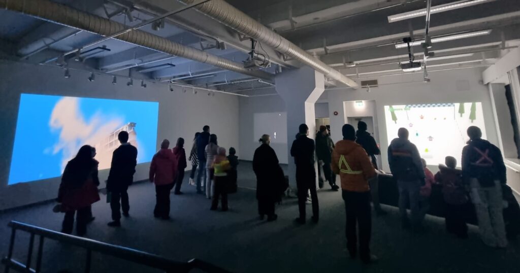 BYOB 2025 perjantai, ihmisiä ja projisointeja näyttelytilassa