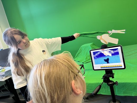 Two children filming an animation.