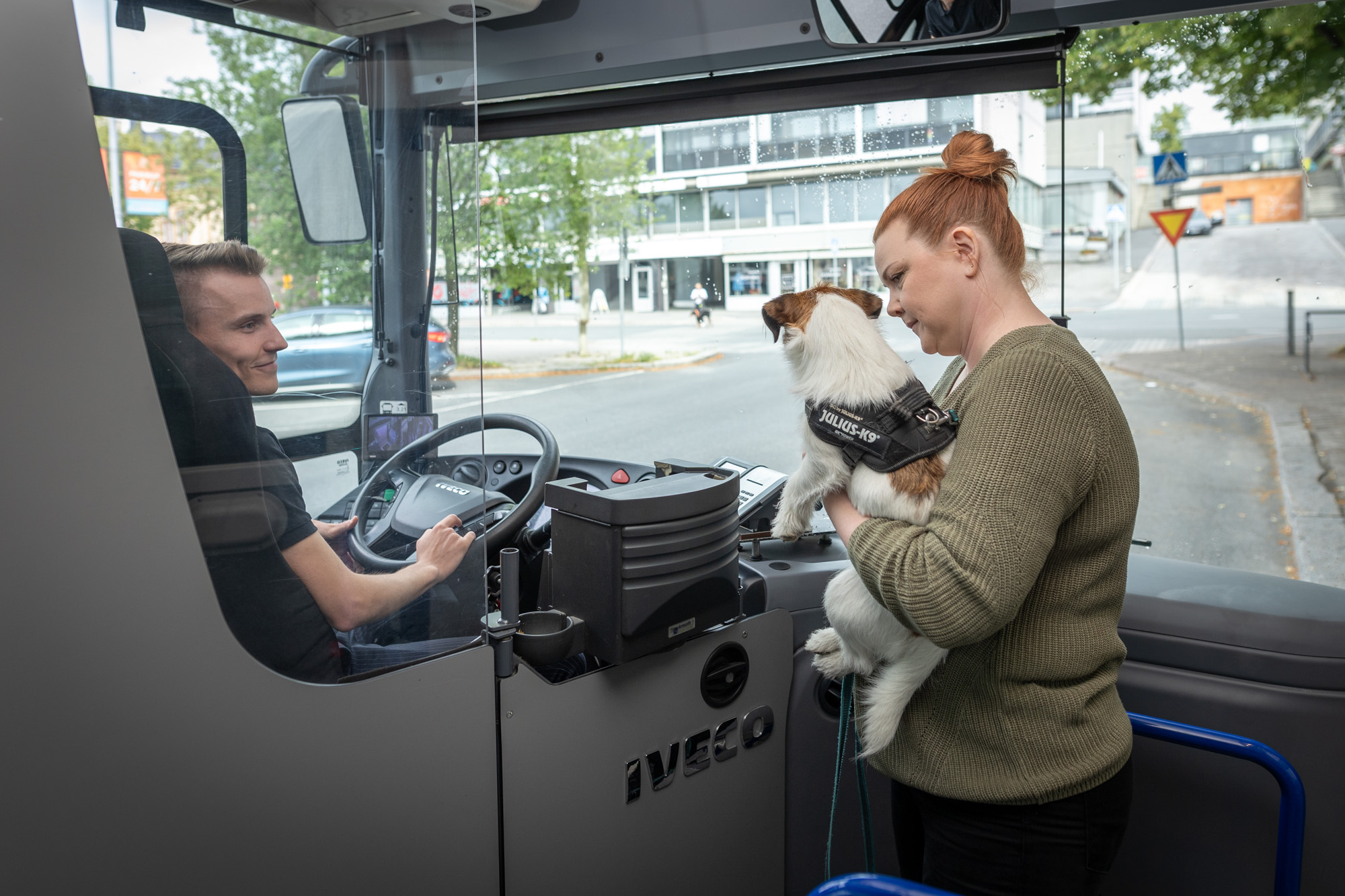 Matkustaja, jolla on pieni koira sylissään, nousee Hämeenlinnan paikallisbussin kyytiin.