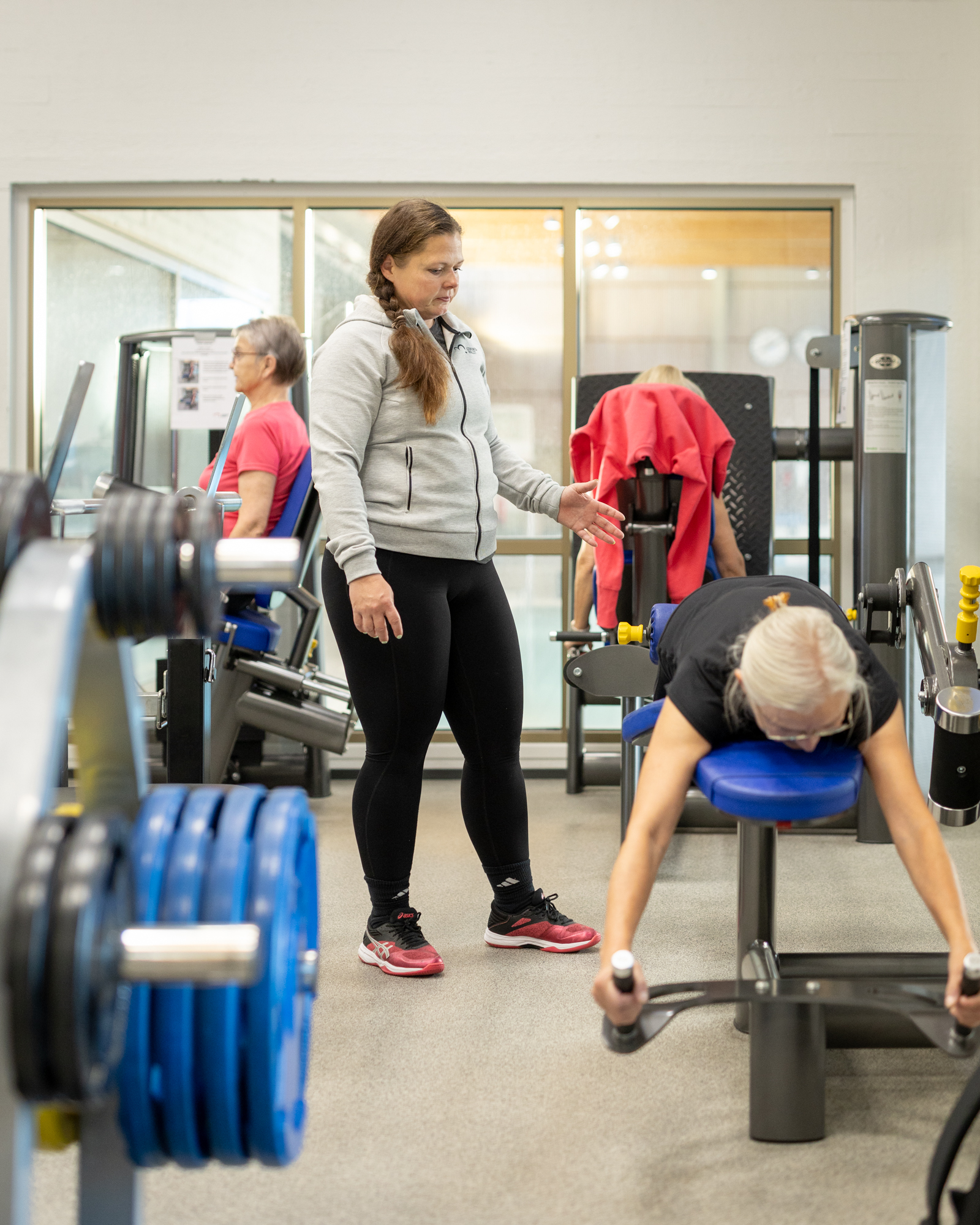 A fitness instructor guides proper exercise technique in the gym
