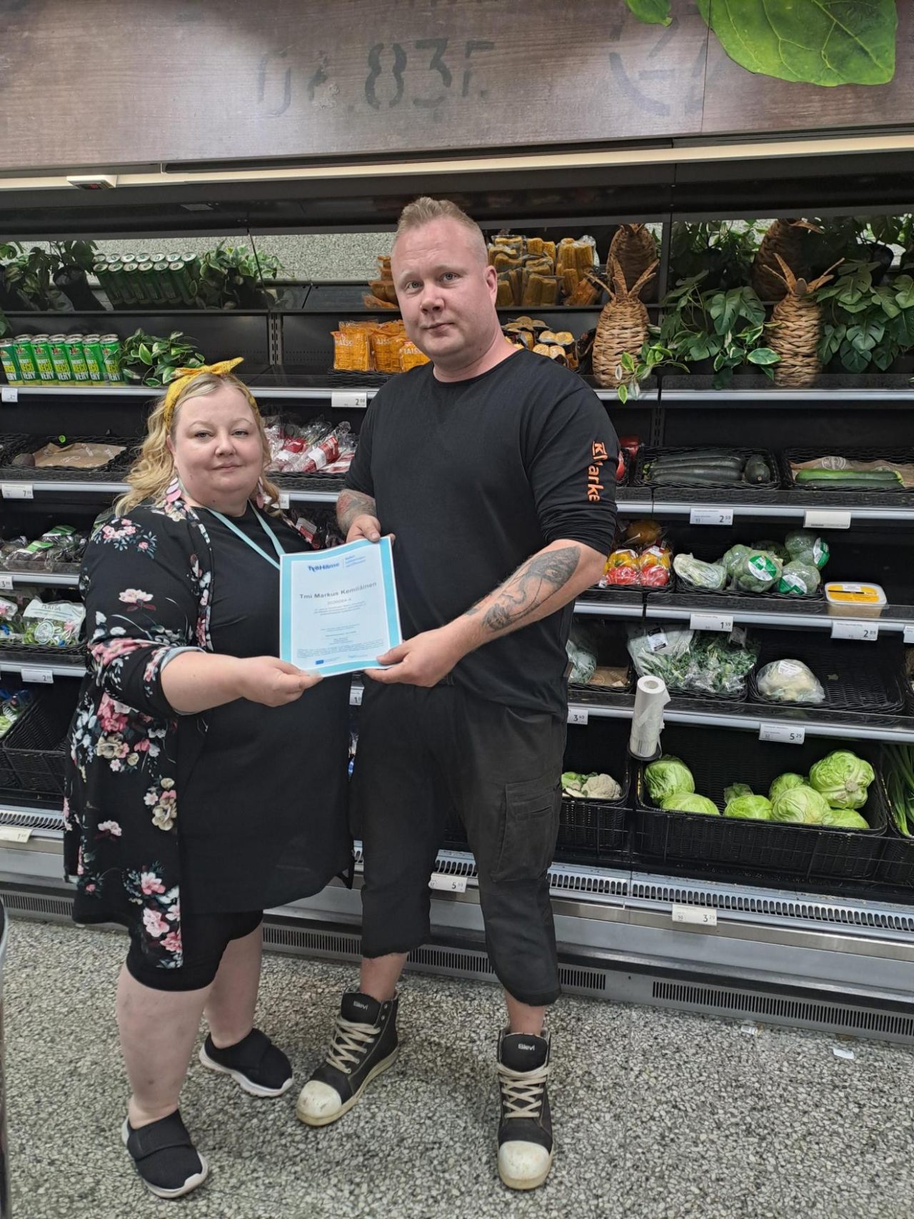 Two people holding a certificate and looking at the camera.
