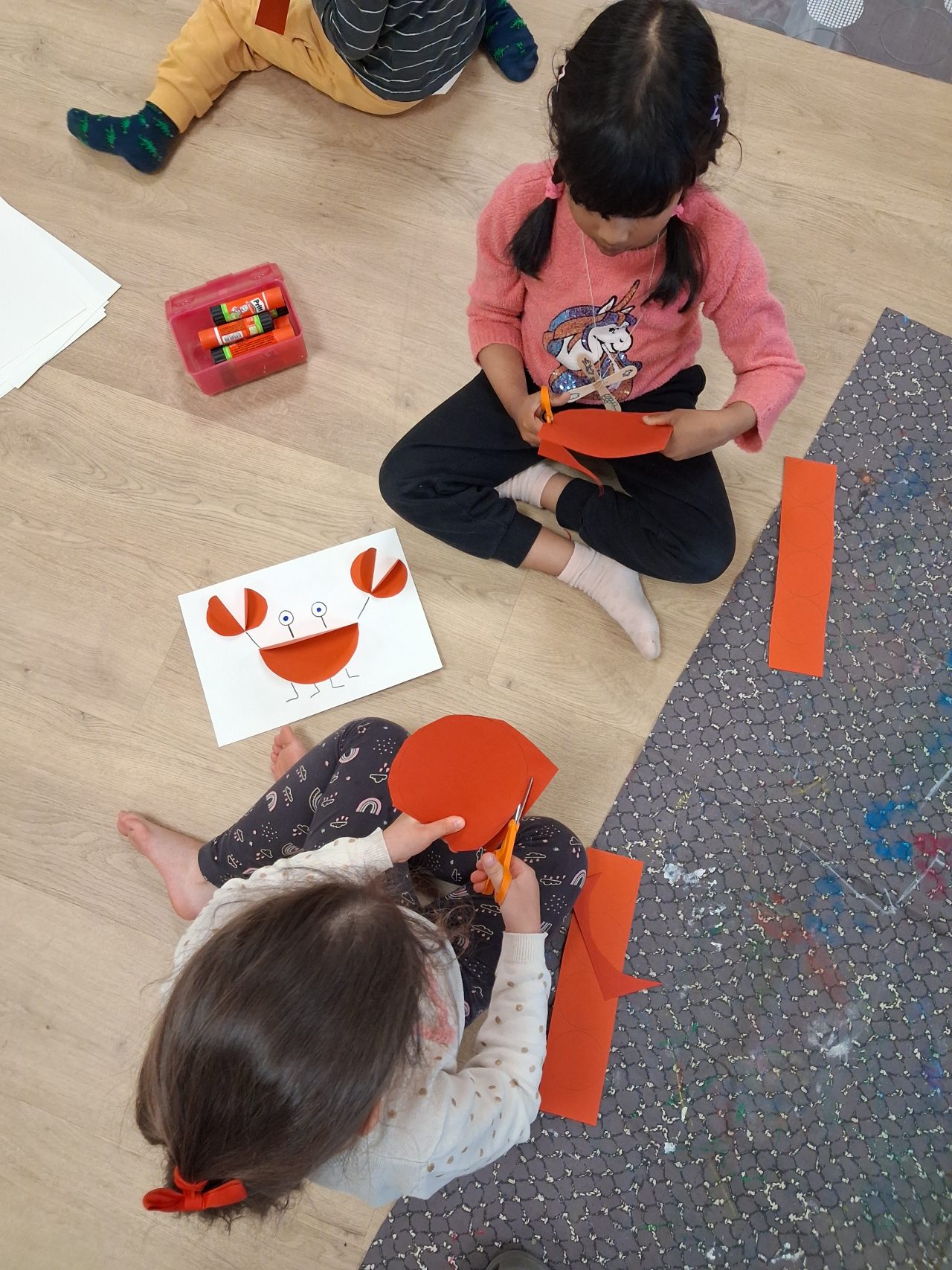 Children doing crafts on the floor of Katuma Early Education Centre.