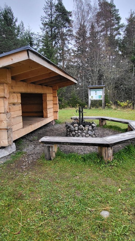 Puinen laavu, jonka edessä on nuotiopiiri.