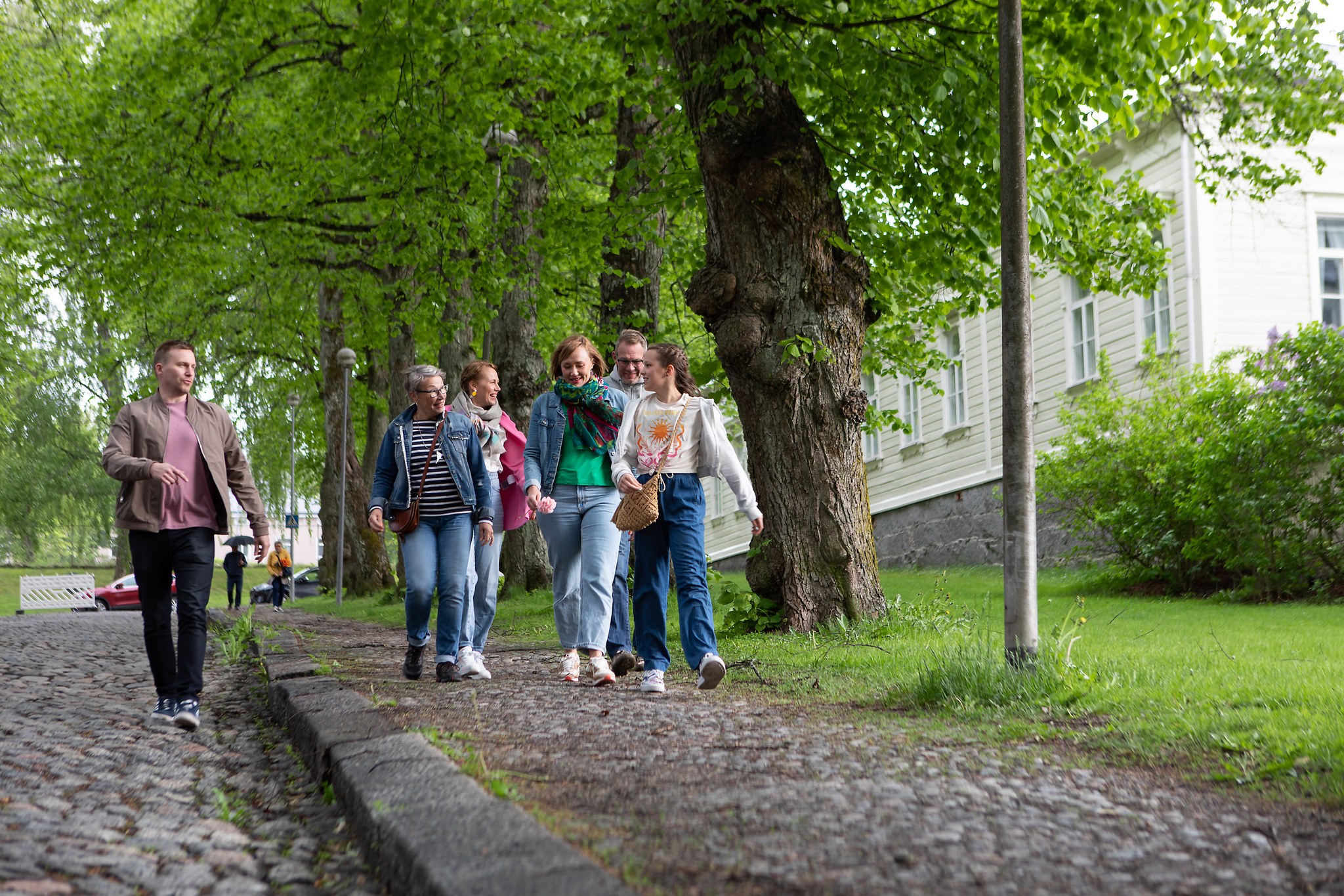 A group of people walking along a cobblestone street